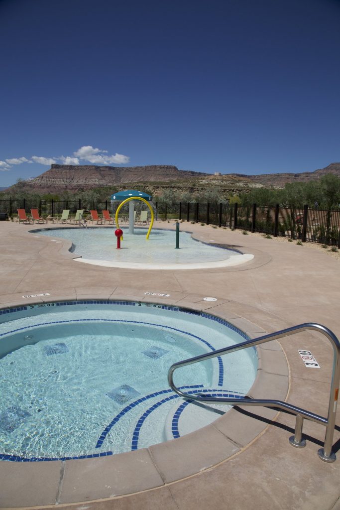 This view looks over the custom spa and kiddie pool area showcasing the beautiful water feature with Zion National Park in the background.