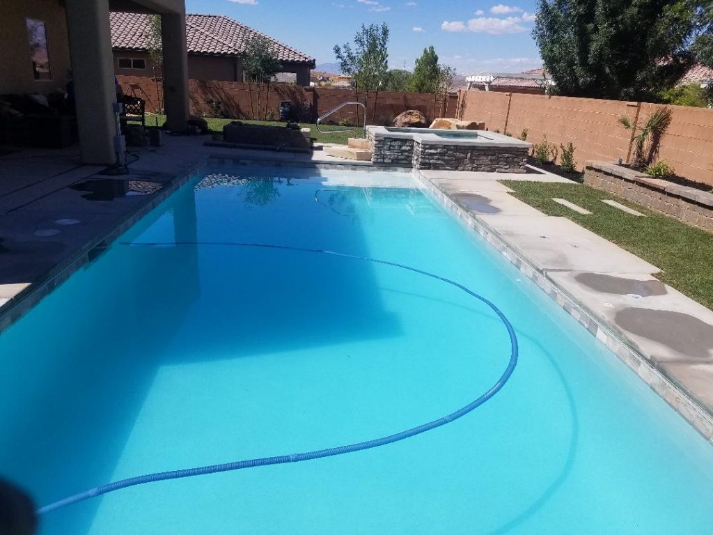 Custom family inground swimming pool in Hurricane Utah with Shamu Shelf and custom spa.