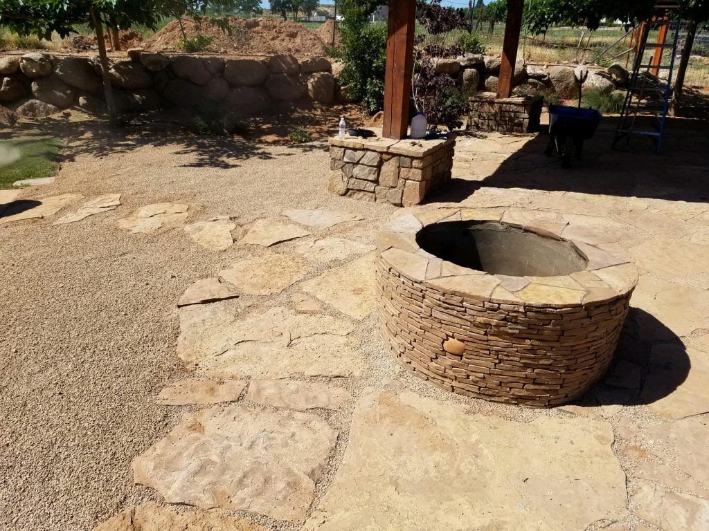 Beautful outdoor gazeebo supported by natural stone pillars with natural stone rock custom firepit in St. George Utah. 